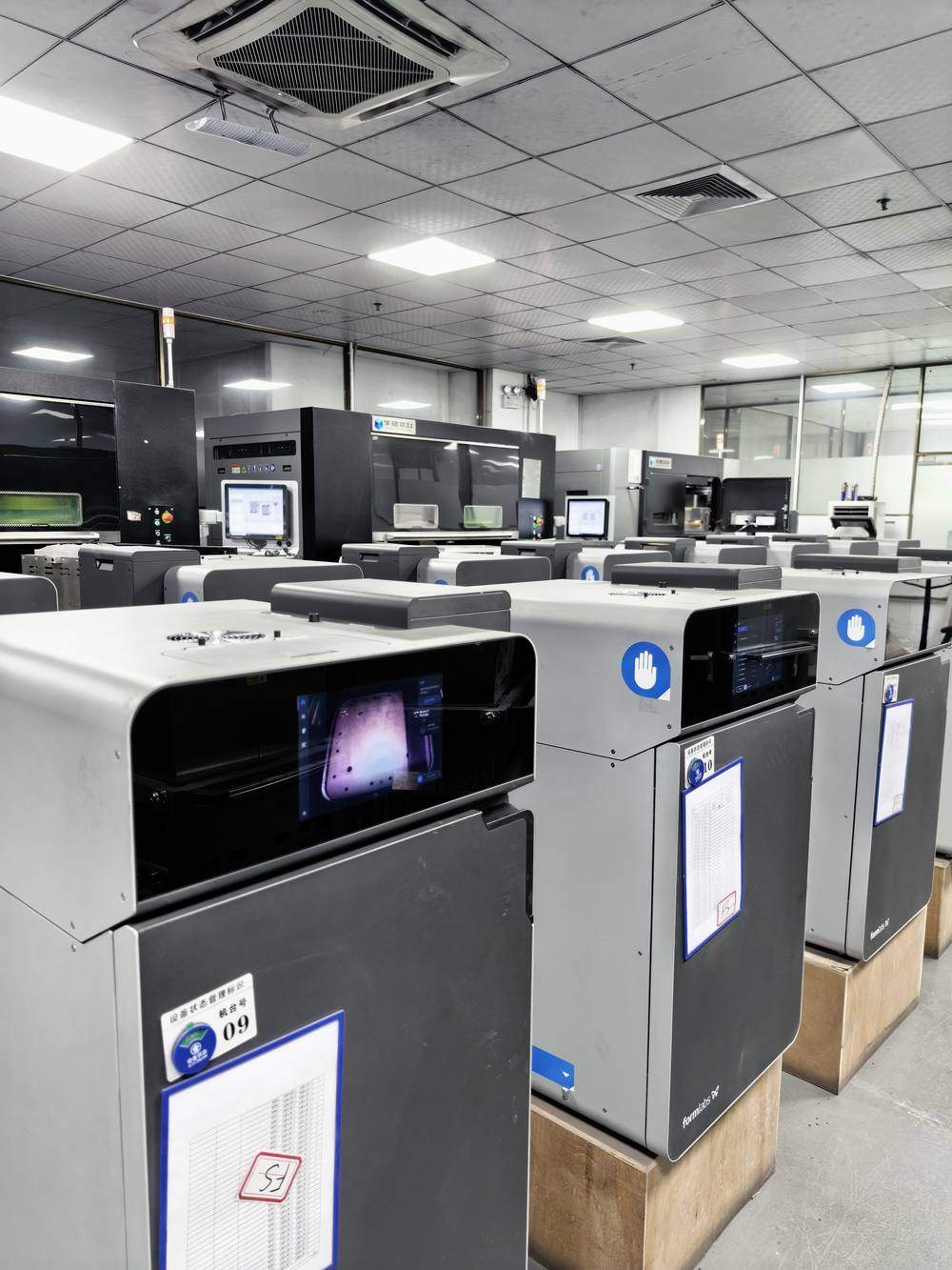 A row of SLS printers on Primofort's production floor